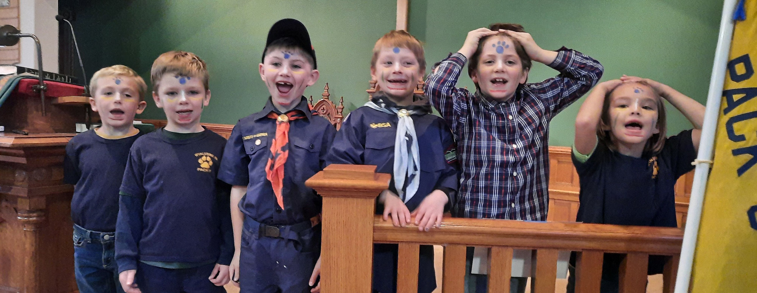 Six new boy and girl cub scouts with bear paws painted on foreheads