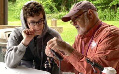 A Bassmasters volunteer teaches a Scout from Troop 50 how to make a fishing fly