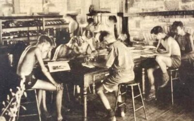 Scout campers studying in front of the fireplace in the Camp Gorton Nature Lodge, sometime in the 1920's or 1930's